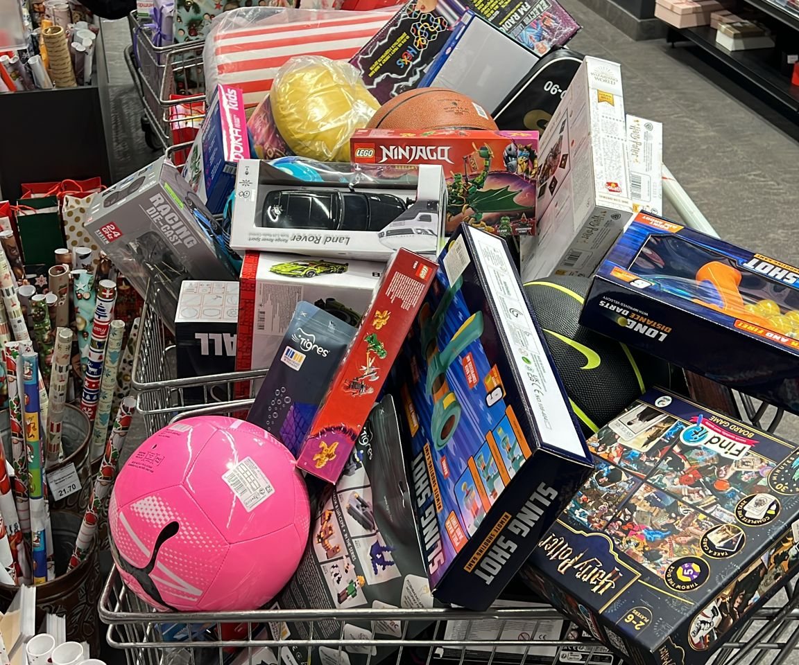 Ein voll beladener Einkaufswagen mit Spielzeug und Geschenken für die Weihnachtsaktion